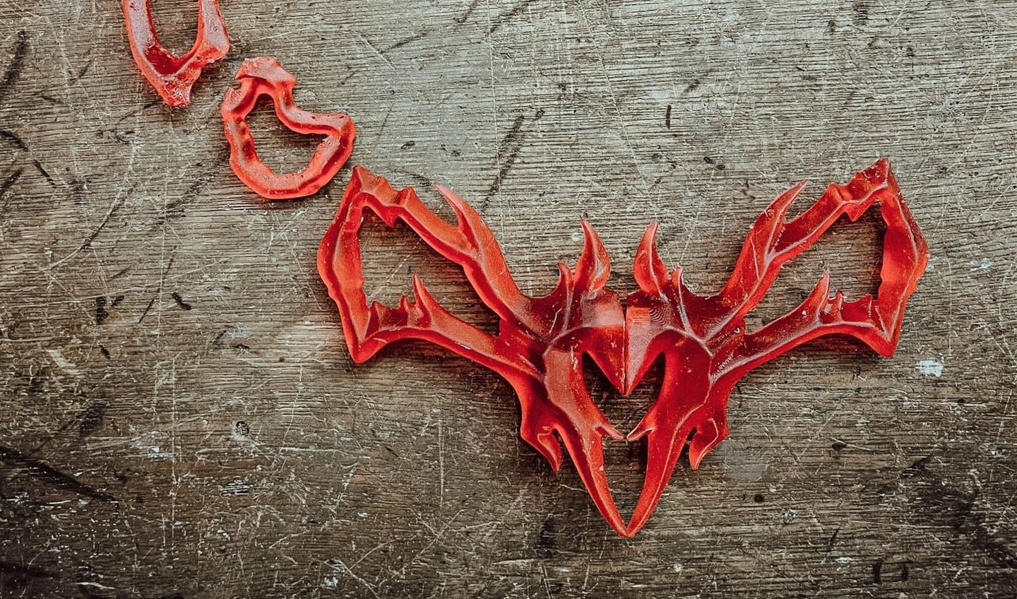 Collar en rojo apoyado sobre una chapa rayada